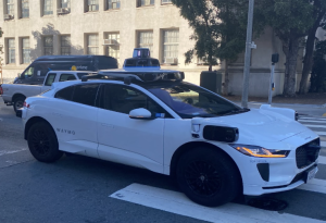 A photo taken of a Waymo car turning into Van Ness Ave.